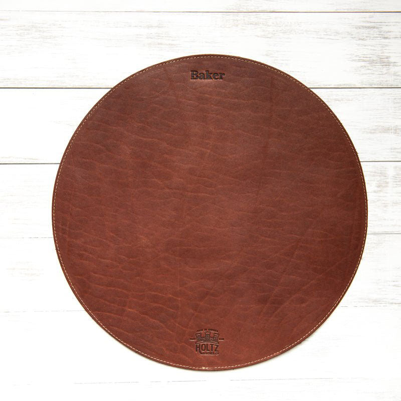 Circle personalized fine leather placemat in rich brown with custom engraving.