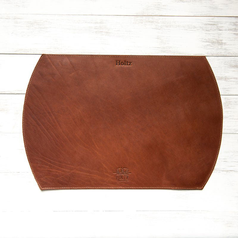 Straight edged oval personalized fine leather placemat in rich brown color with embossed logo.