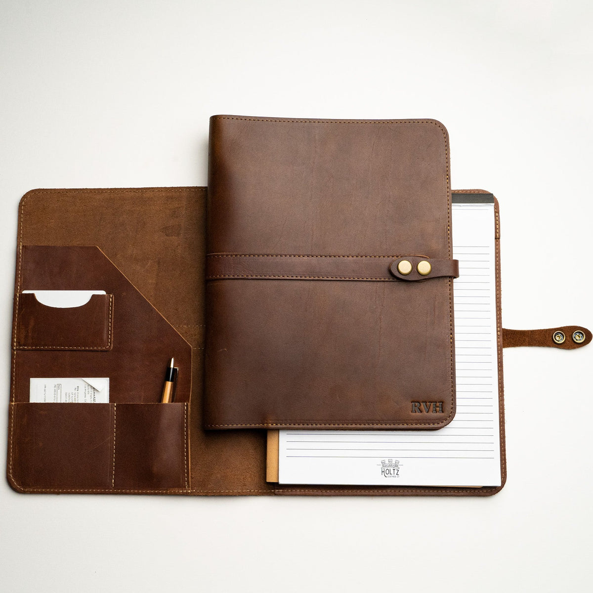 Leather journal shown both open and closed; Outside has personalized initials and inside include a journal and pockets for papers, business cards, and pens; from Holtz Leather Co in Huntsville, Alabama