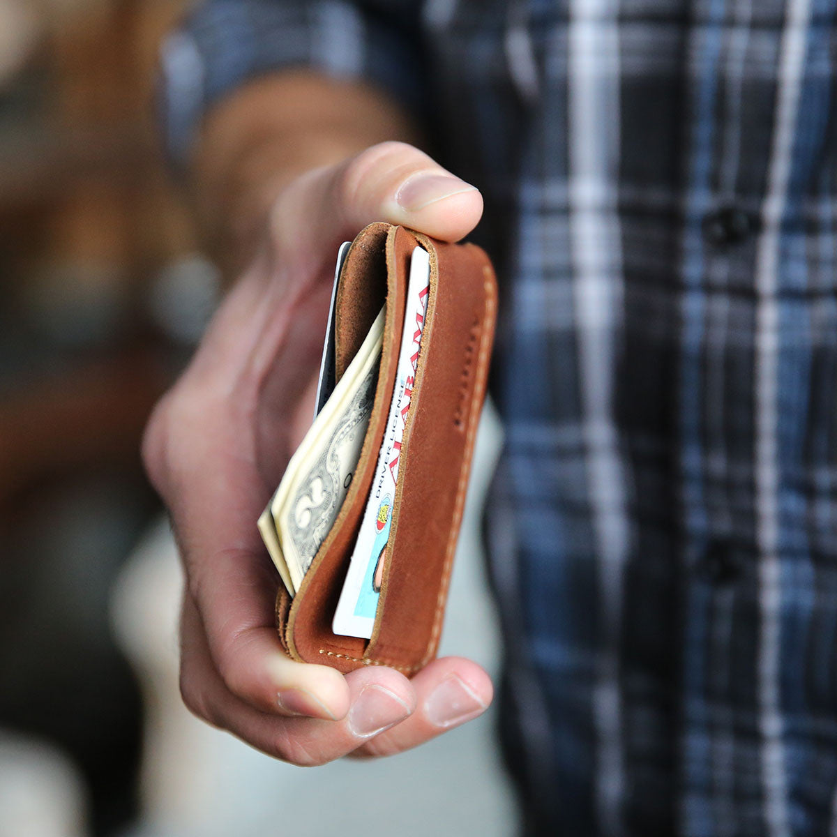 Fine leather triple sleeve front pocket wallet in a person&#39;s hand