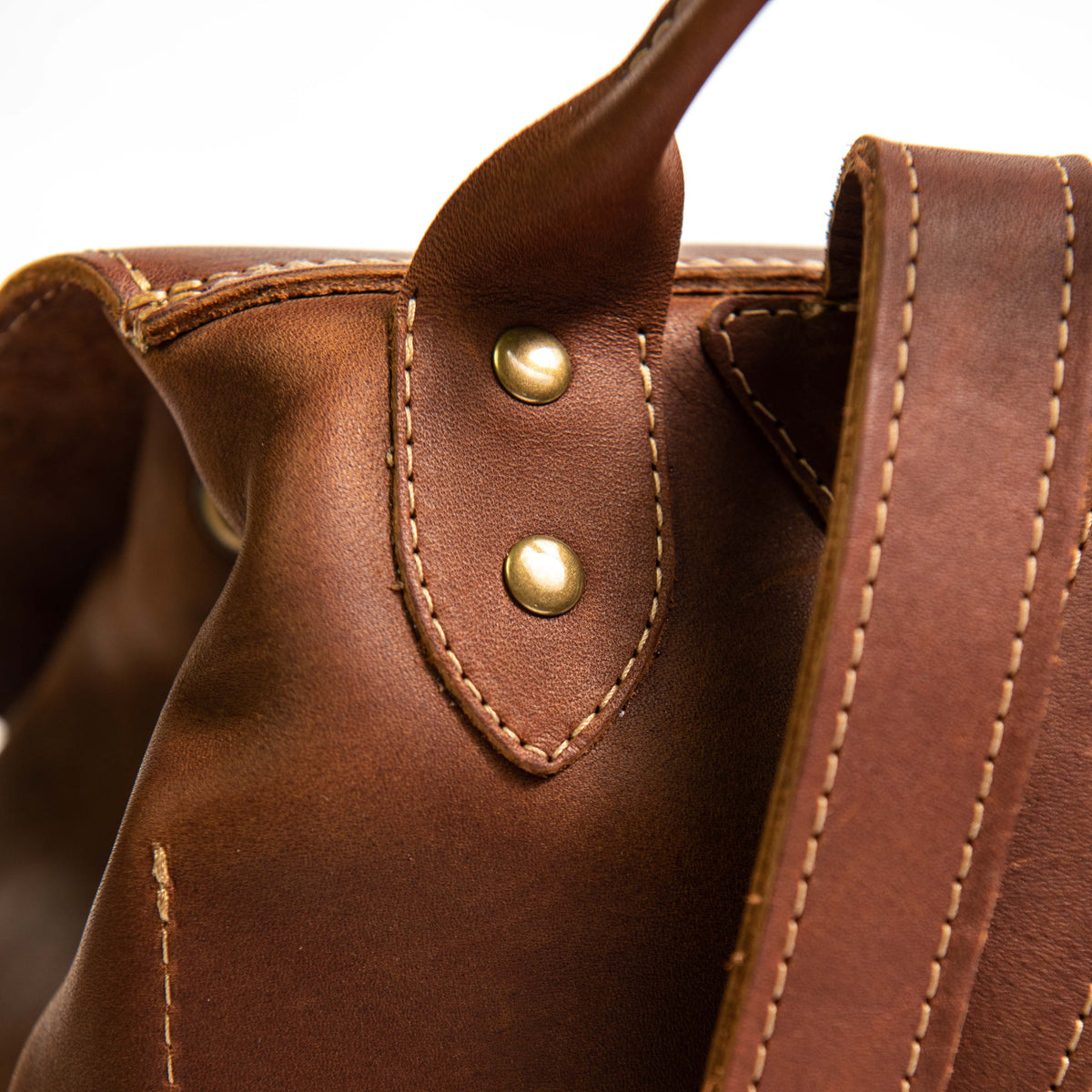 Hand made full grain leather backpack with drawstring slap closure. It features a main compartment with an interior pocket, two outer pockets, and a side pocket. Available in black or brown leather.