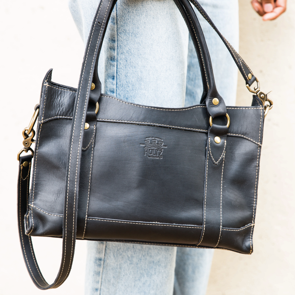 Fine leather handbag over a woman's shoulder at Holtz Leather Co in Huntsville, Alabama