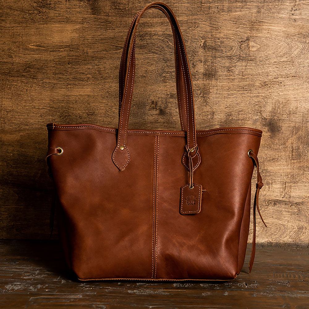 Handcrafted fine leather tote bag being held by woman at Holtz Leather Co in Huntsville, Alabama