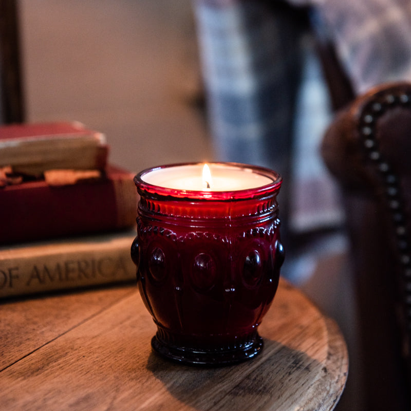 Saturday Morning scented candle in vintage red glass jar sitting on top of wooden table, hand-poured by Holtz Leather Co in Huntsville, Alabama