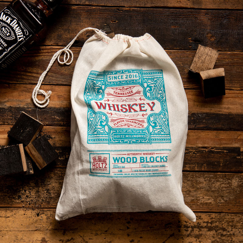 Wood block flavor enhancers from Tennessee Whiskey Barrel wood. In a white and blue bag