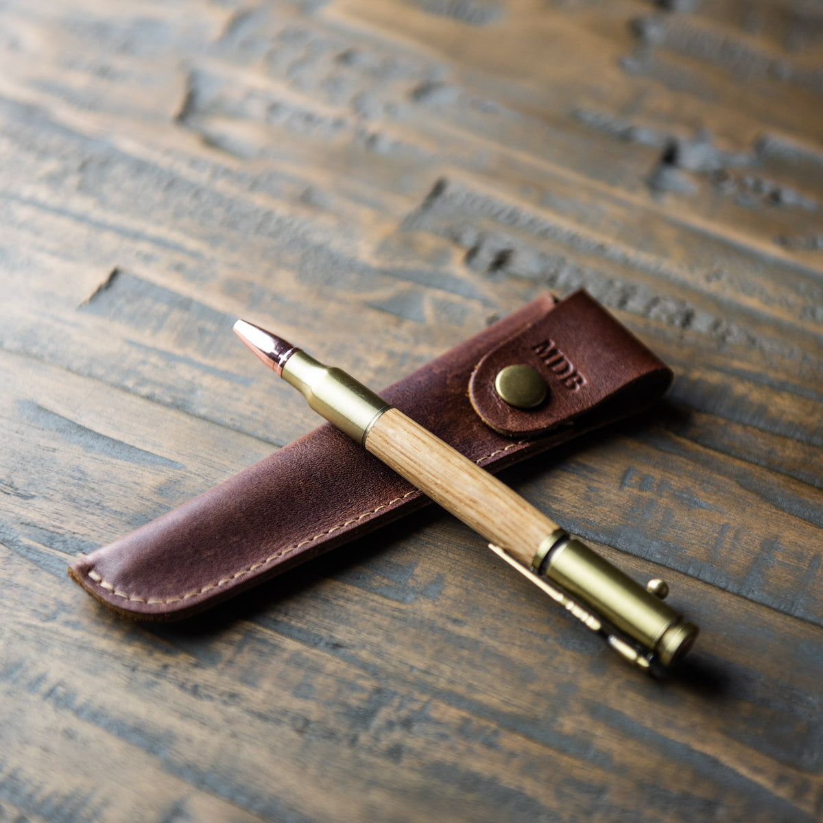 .30 caliber bolt action pen made of Tennessee Whiskey Barrel wood with a personalized leather pen sleeve 